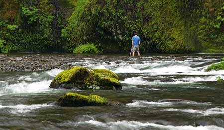 Photographer standing in Eagle Creek for the "classic" shot of Punch Bowl Falls