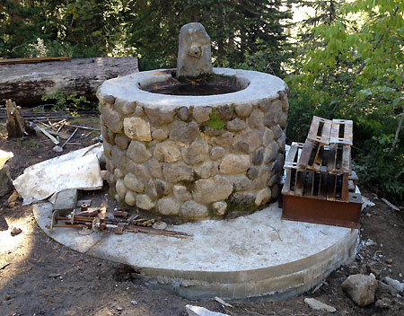 This view shows the new concrete footing in place on downslope side of the old fountain