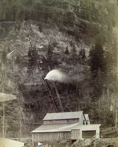 This 1890s photo shows water spouting from the long penstock that drove Myron Kelly's pulp mill