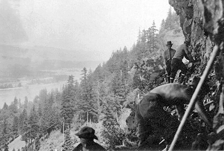 Civilian Conservation Corps crew building the catwalk section of the McCord Creek Trail in 1936 (highway bridge visible in lower left corner of photo)