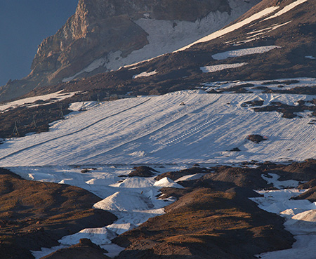 Like tractors on a corn field, snowcats plow (and salt) the Palmer Glacier for summer skiers